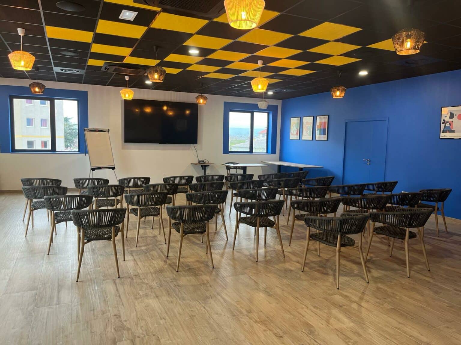 Grande salle de séminaire lumineuse à La Tapa Loca avec écran de présentation et paperboard